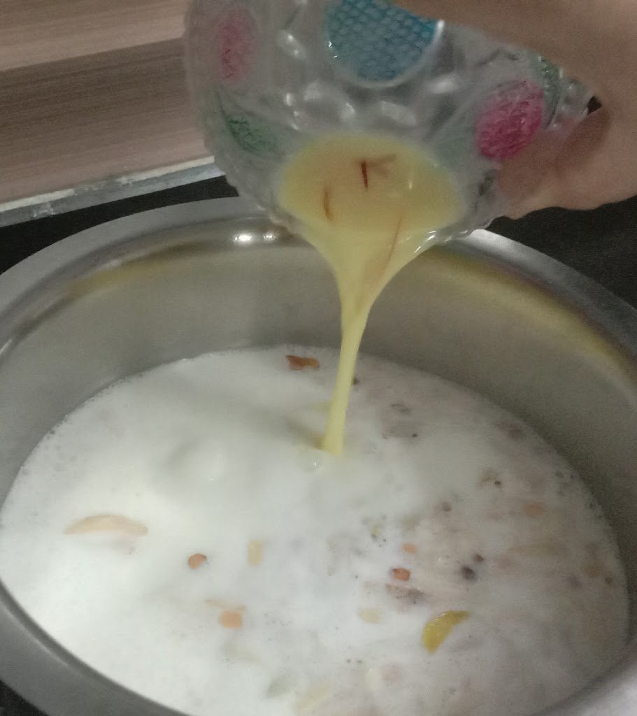 Adding saffron milk into milk, rice kheer recipe.