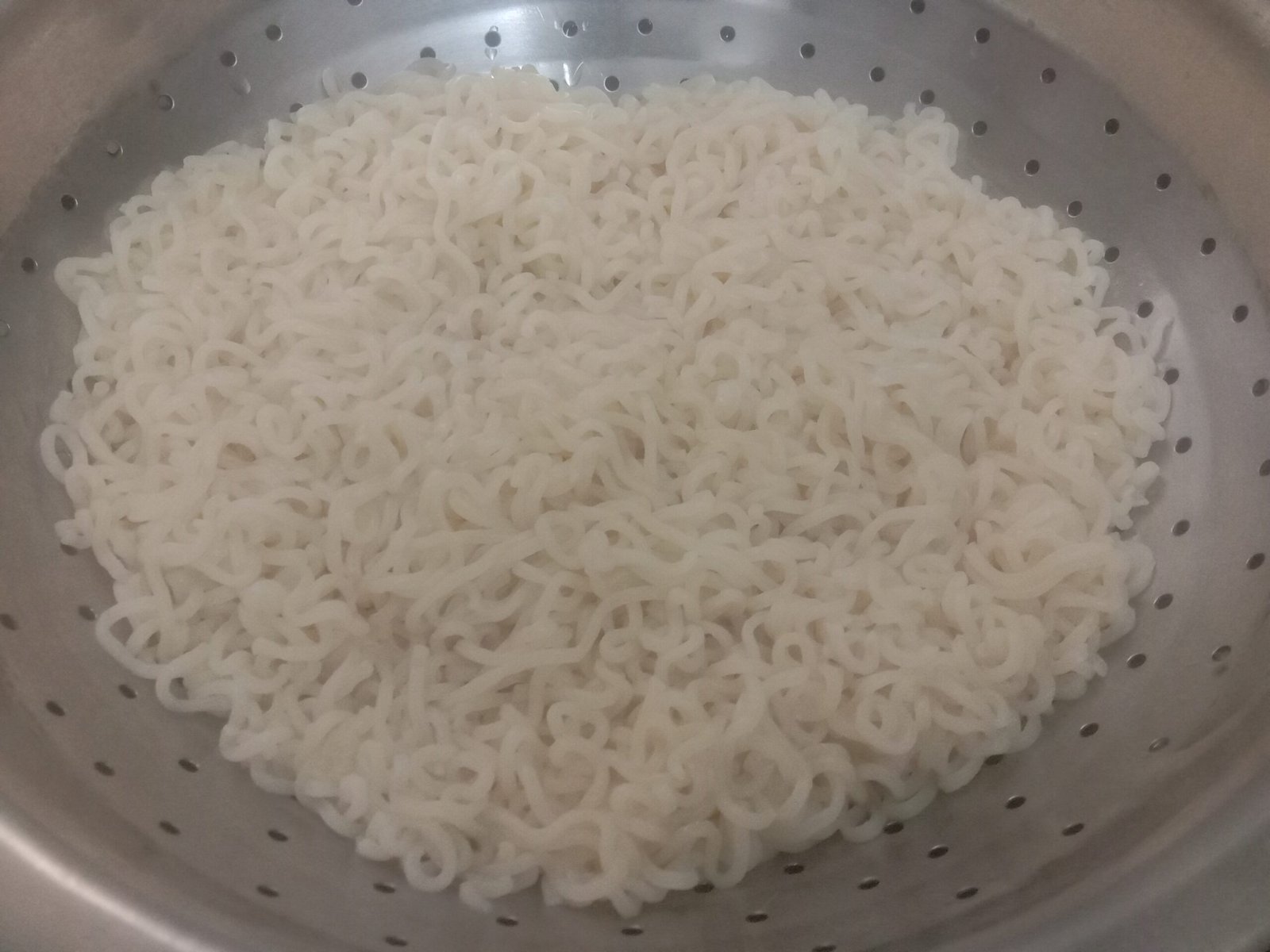Draining water by putting maggi in colander, Egg bhurji maggi noodles recipe.