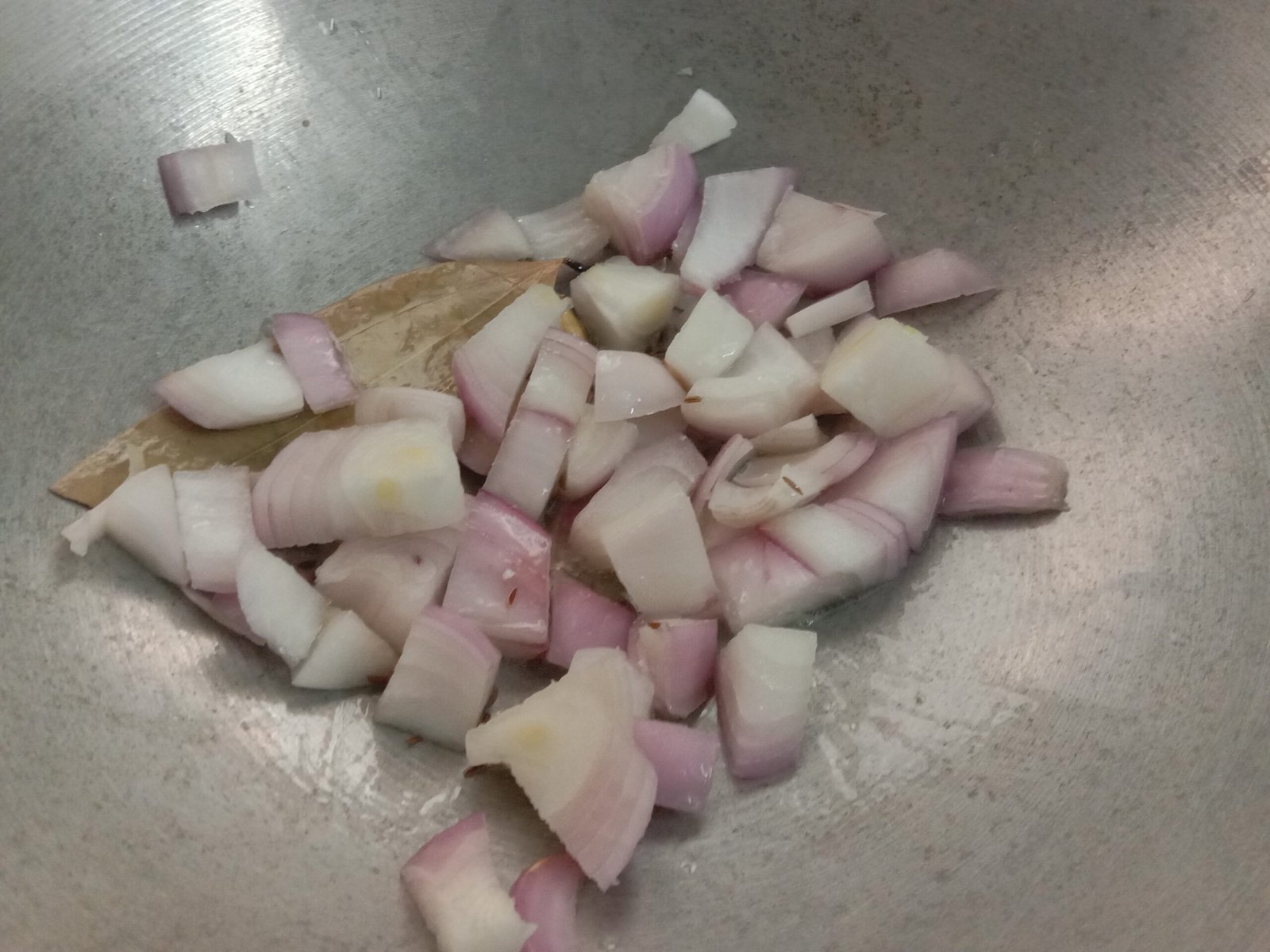 Adding onion to spices in kadhai, Butter paneer recipe.