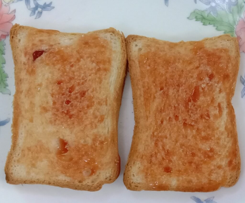 Applying tomato ketchup on bread, Bread pakoda recipe.