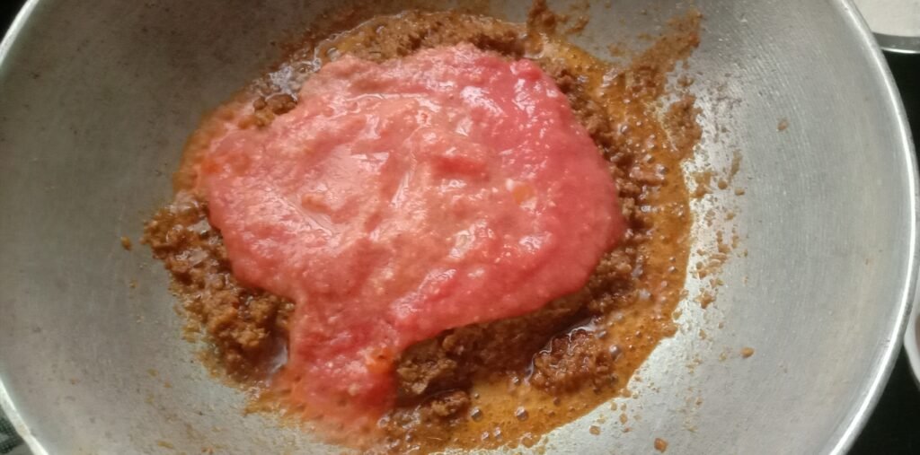 Adding tomato puree to kadhai, Chicken kolhapuri sukka-curry recipe.