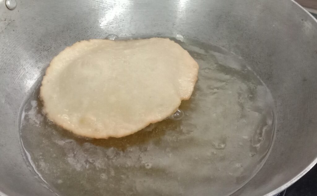 Frying bhatura in cooking oil, Chole bhature recipe.