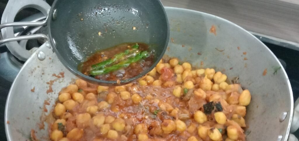 Adding chilli tadka to masala, Chole bhature recipe.