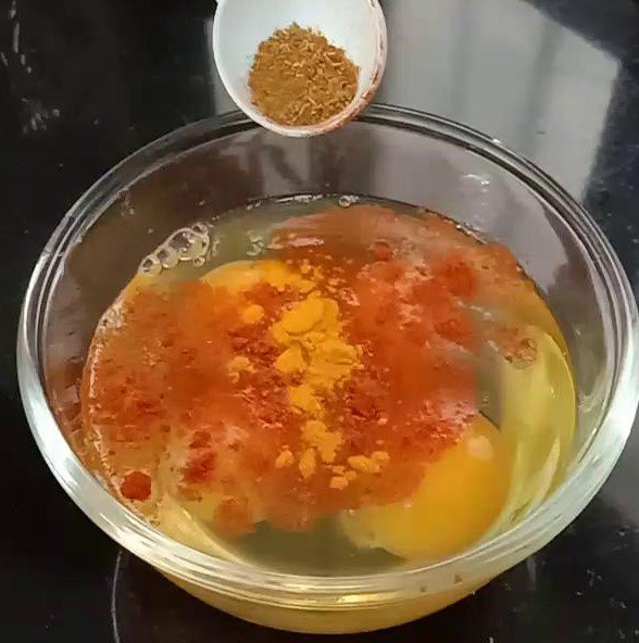 Adiing spices to egg, Egg sandwich recipe.