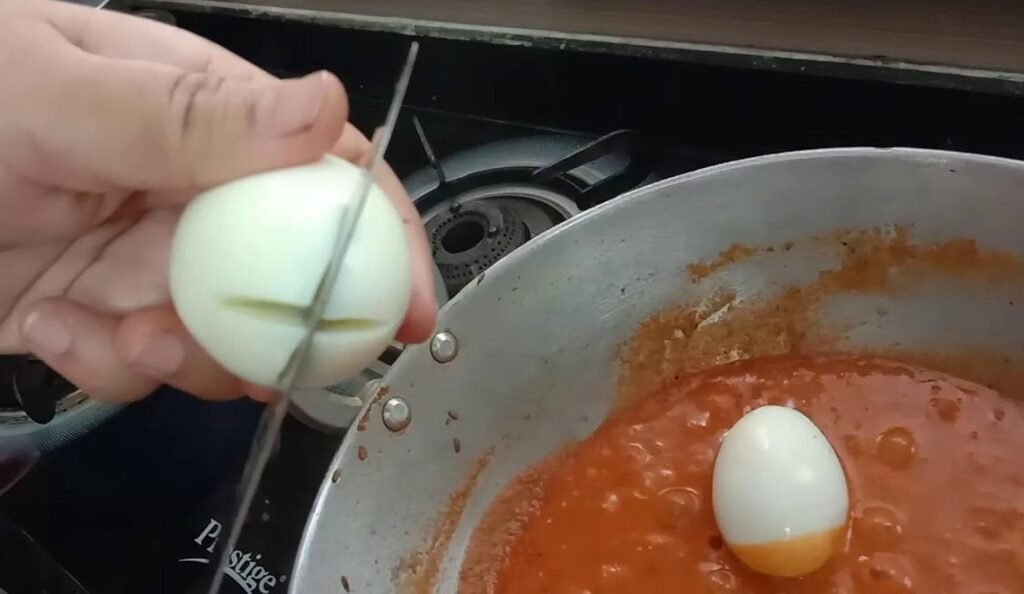 Cutting cross on egg, Egg masala recipe.