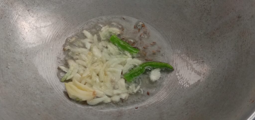 Adding garlic, jeera and chilli in oil, Methi bhaji recipe.