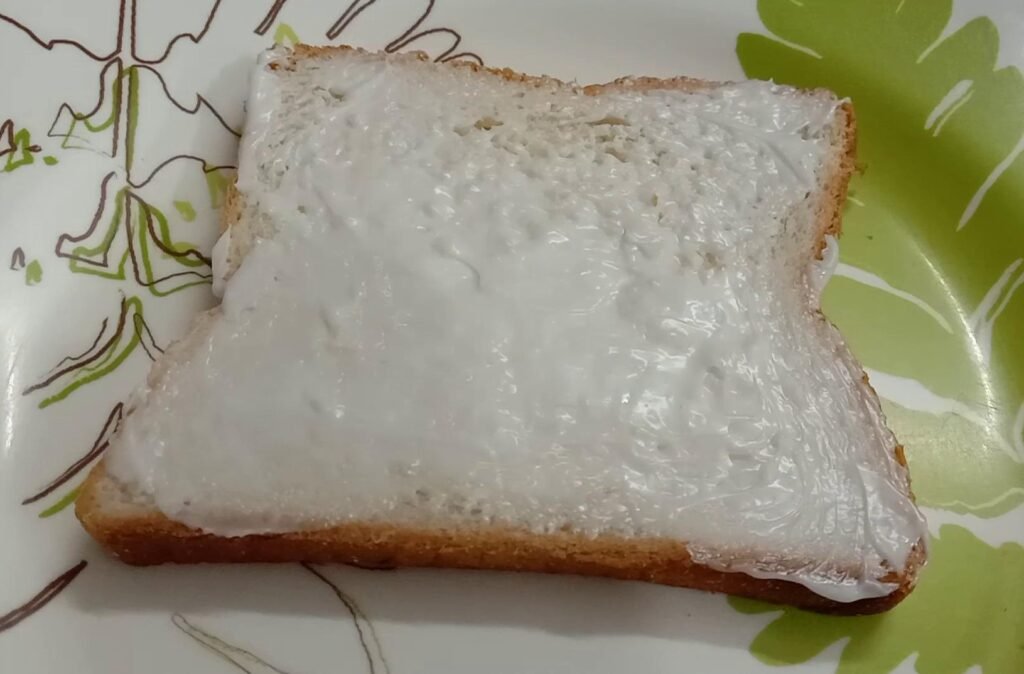 Spreading mayonnaise on bread slice, Garlic bread slice.