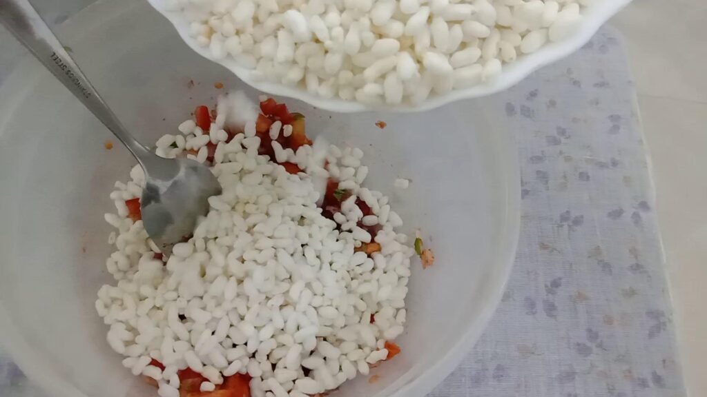 Adding puffed rice to mixture, Bhel recipe.