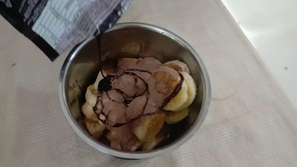 Banana pieces with cocoa powder and chocolate syrup, Frozen yogurt.