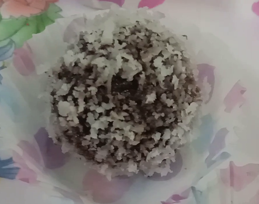 Spreading grated coconut over date ball, Energy date balls. 