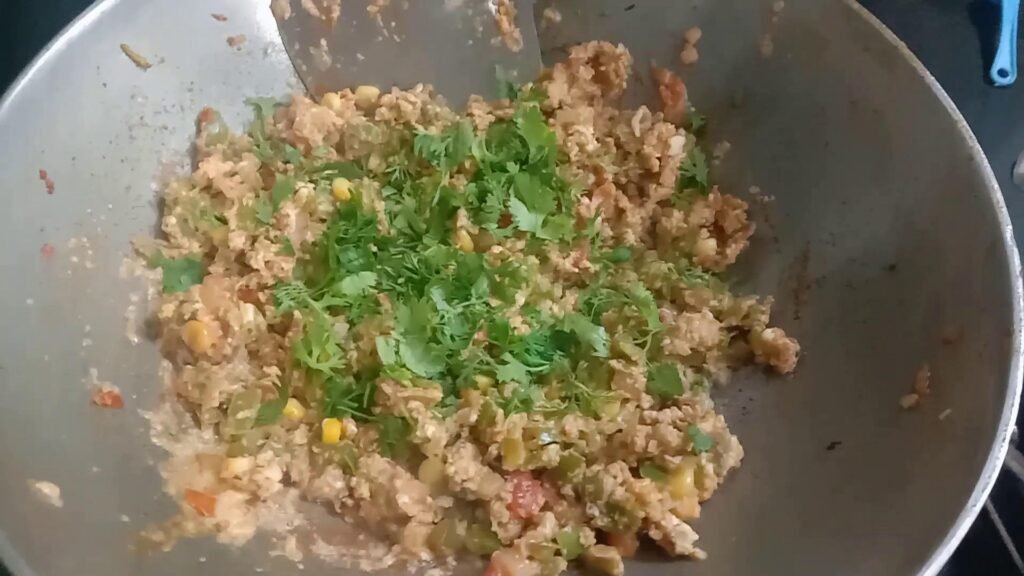 Adding coriander leaves to bhurji.
