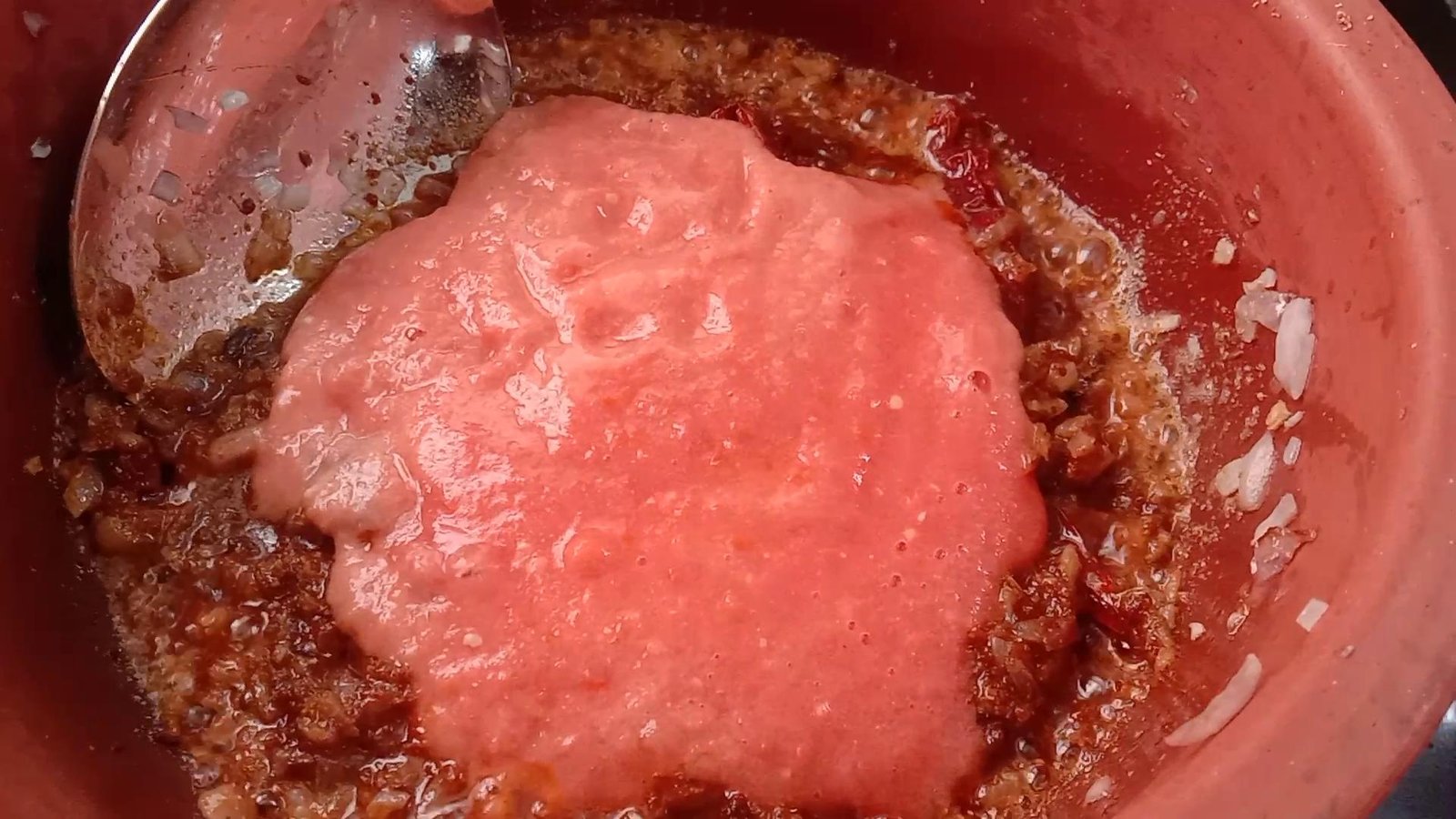 Adding Tomato Puree to Clay pot, Chicken Handi recipe.
