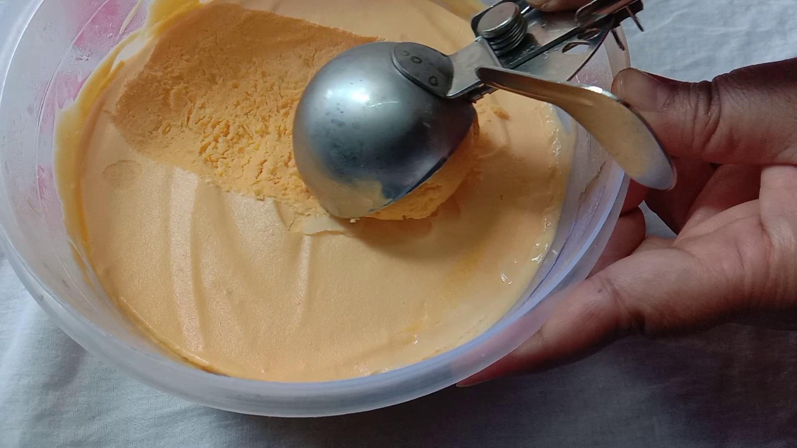 Removing ice cream with scooper, Mango Ice cream.
